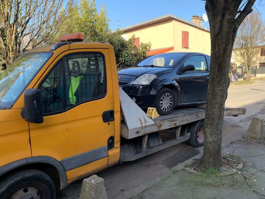 Citroën C2 noire chargée sur le plateau de la dépanneuse Sprint Épave, dans une rue pavillonnaire